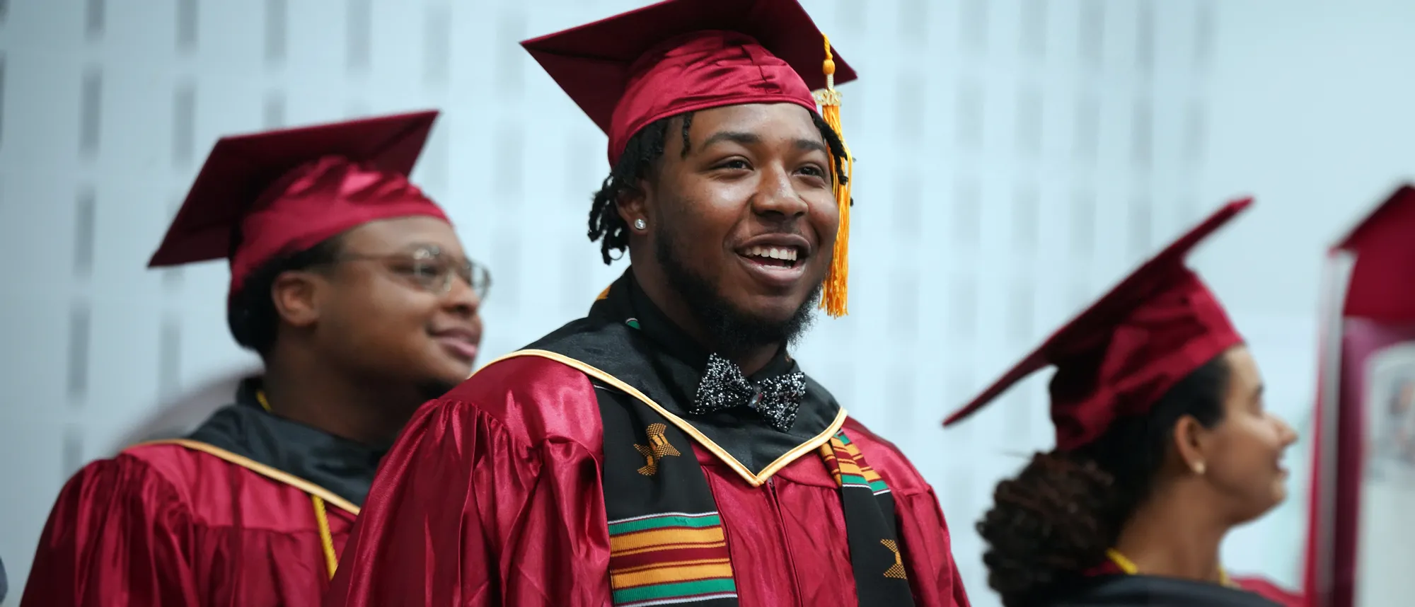 A young man in a cap and gown attending a commencement ceremony