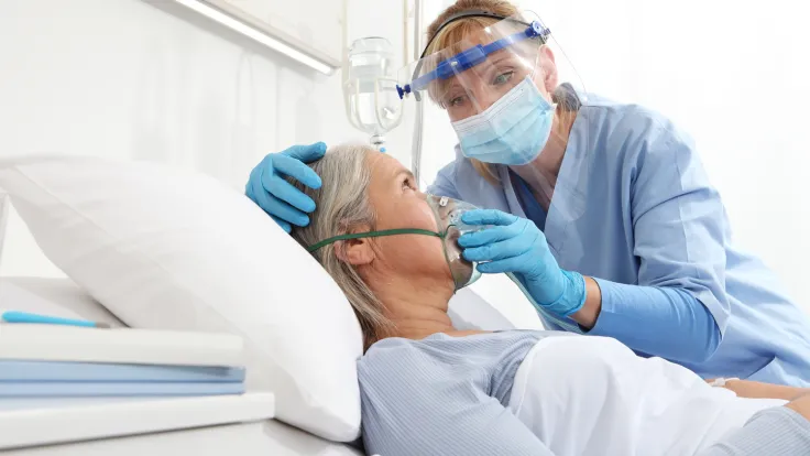 a respiratory therapist fits a patient with a nebulizer