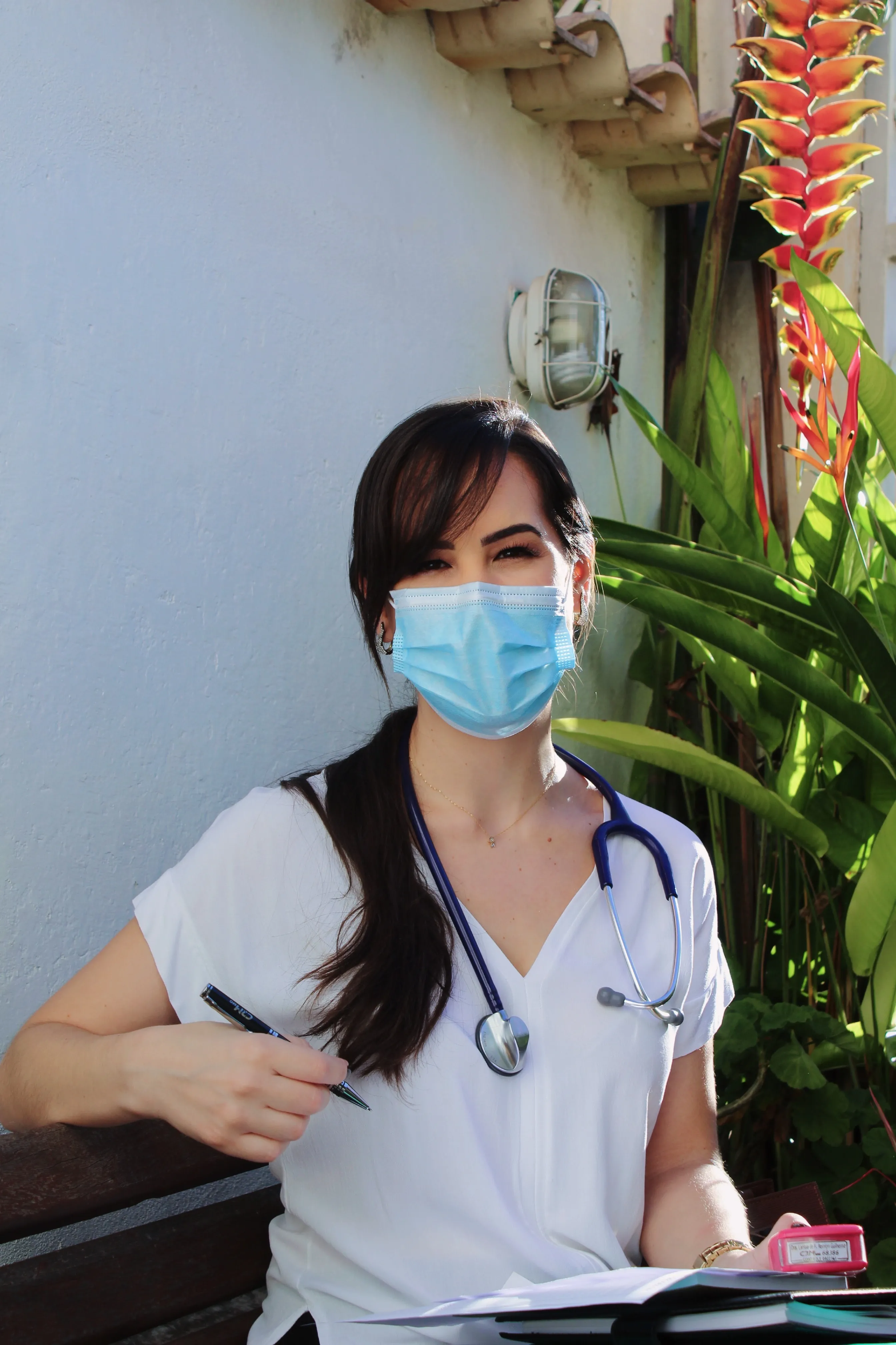 female nurse with mask sitting on bench outside