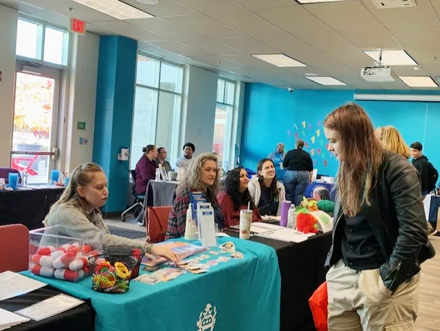 A student meeting with a community partner at last year's resource fair tables