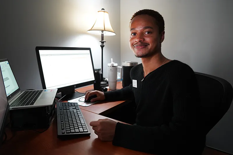 A staff member working at his desk in the Student Services Center