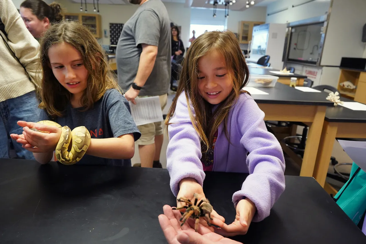 Two students interacting with live animals