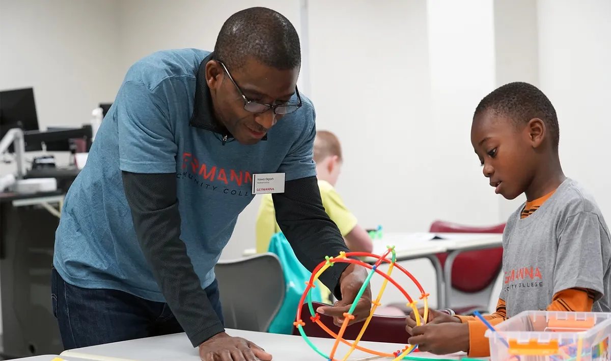 A Germanna instructor helps a student explore a science demonstration at the annual STEAM-H Day