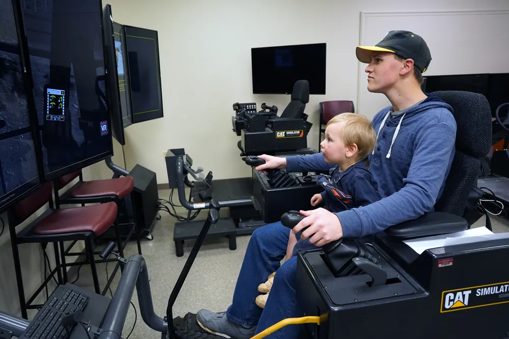An attendee and his younger brother shown exploring Germanna’s heavy equipment operation simulator
