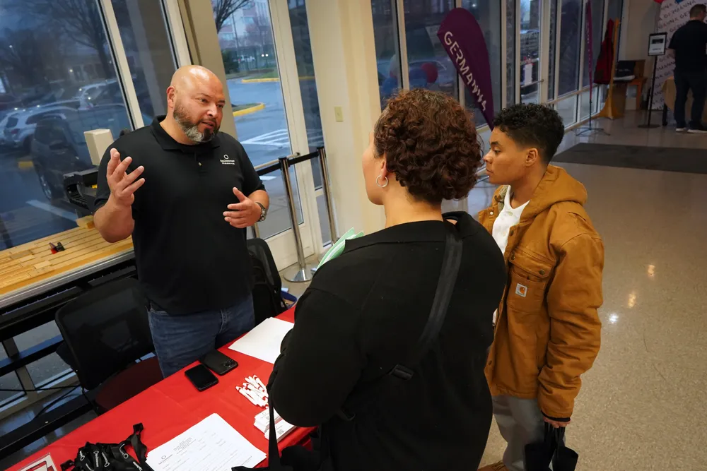 A representative from Day & Zimmerman shown speaking with attendees