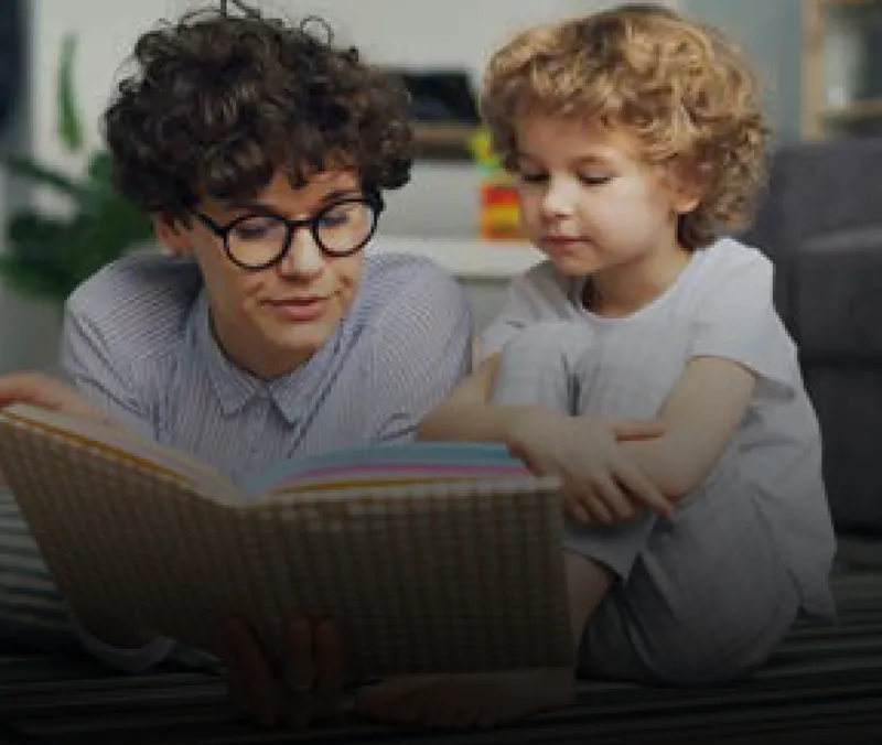 A teacher reads a story to a young child