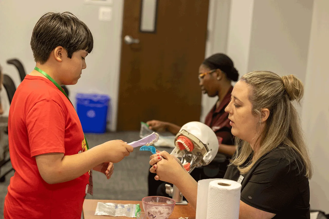 Dental Hygiene and Dental Assisting Professor Stephanie Bettis (right) participating in a dental activity with a student