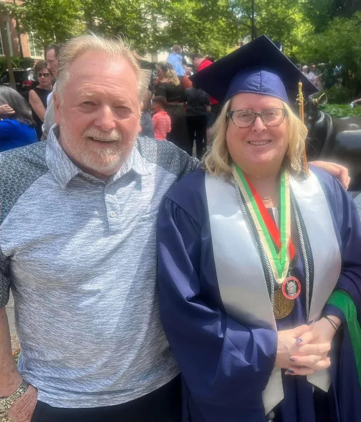 Professor Kobersteen (right) shown with her father after graduating with her second master’s degree from The George Washington University