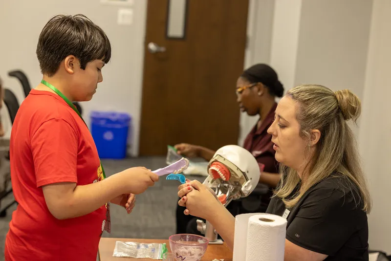 Professor Stephanie Bettis participating in a dental activity with a student at the Operation Health Sciences summer camp held this summer