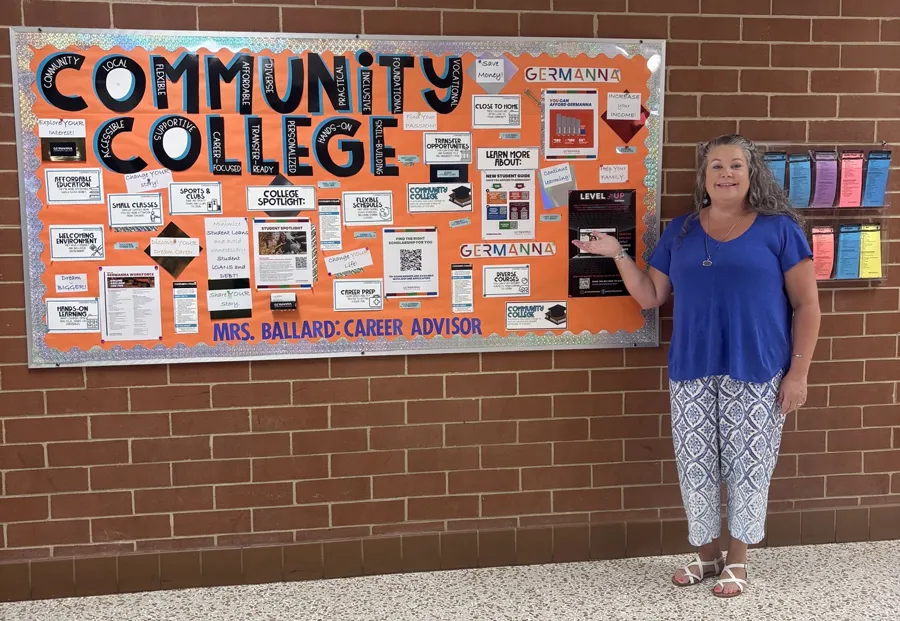 Career Advisor Cara Ballard standing beside an informational bulletin board about Germanna at Spotsylvania High School
