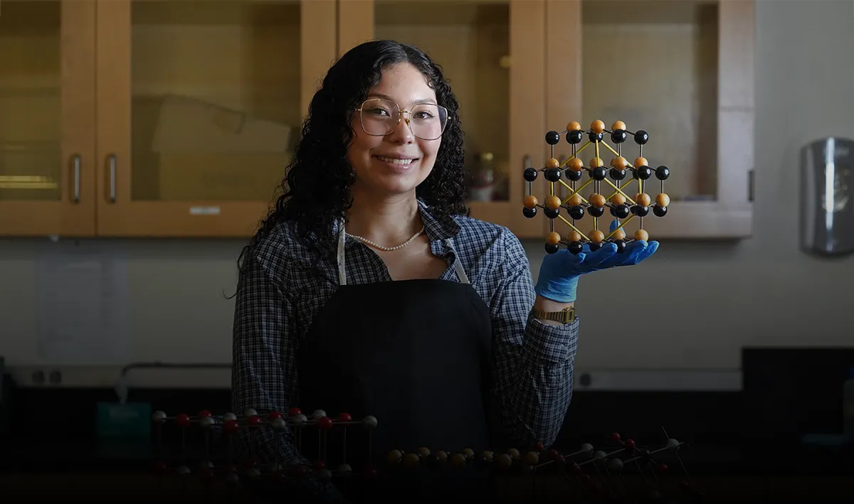 Aurora Pagan holding up a molecular model in a chemistry lab