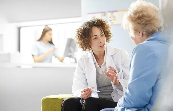 A behavioral health technician talks to a patient