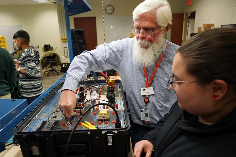 Engineering Professor Kenneth Jaskowiak engaging with a student during an engineering workshop