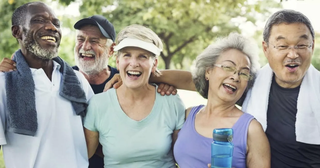Five older people in workout clothes pose for a photo together