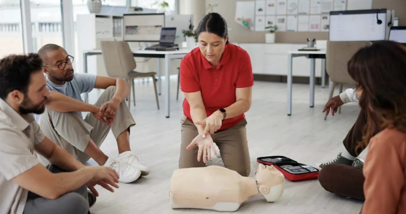 An instructor demonstrates hands-only CPR techniques on a dummy