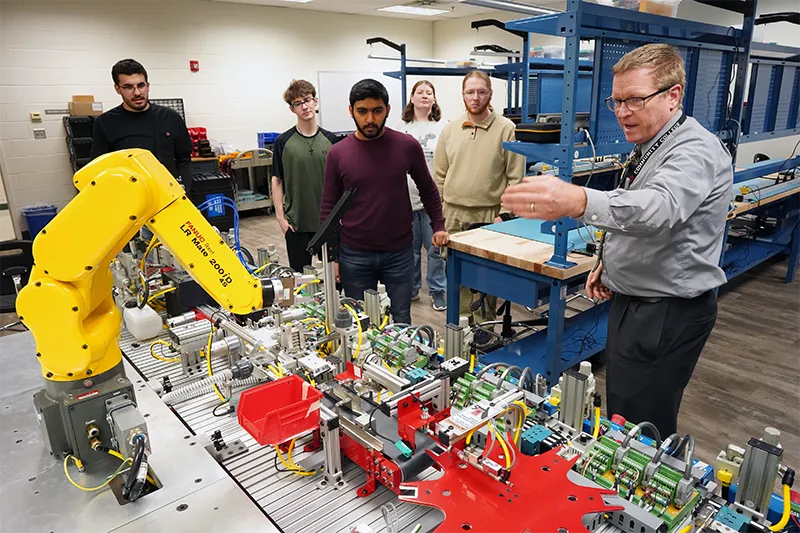 A Germanna professor demos robots to several students in a Mechatronics class
