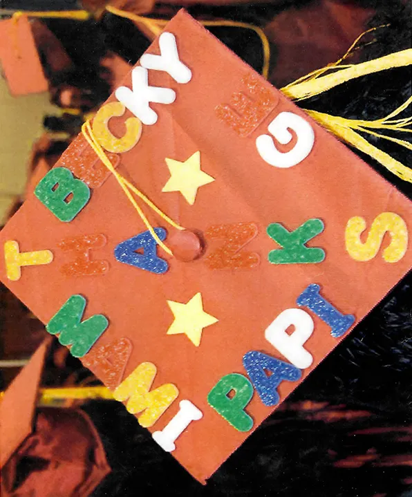 A graduation cap bearing the messages "Thanks Mami, Papi, GE, Becky"