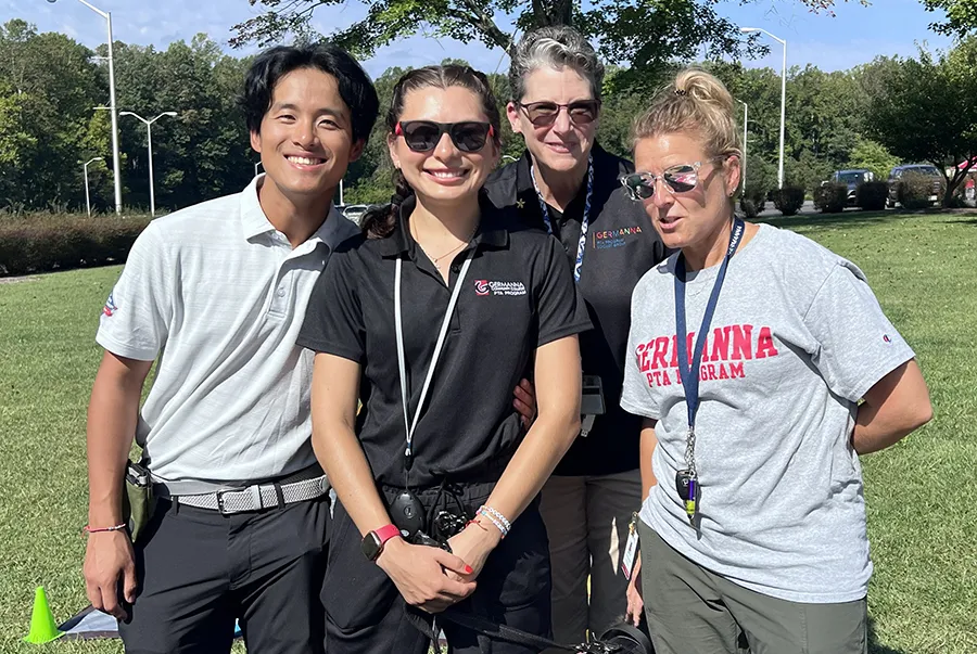 Four Germanna staff members gather on campus on a sunny day to welcome visitors to the Connected Community Fall Festival