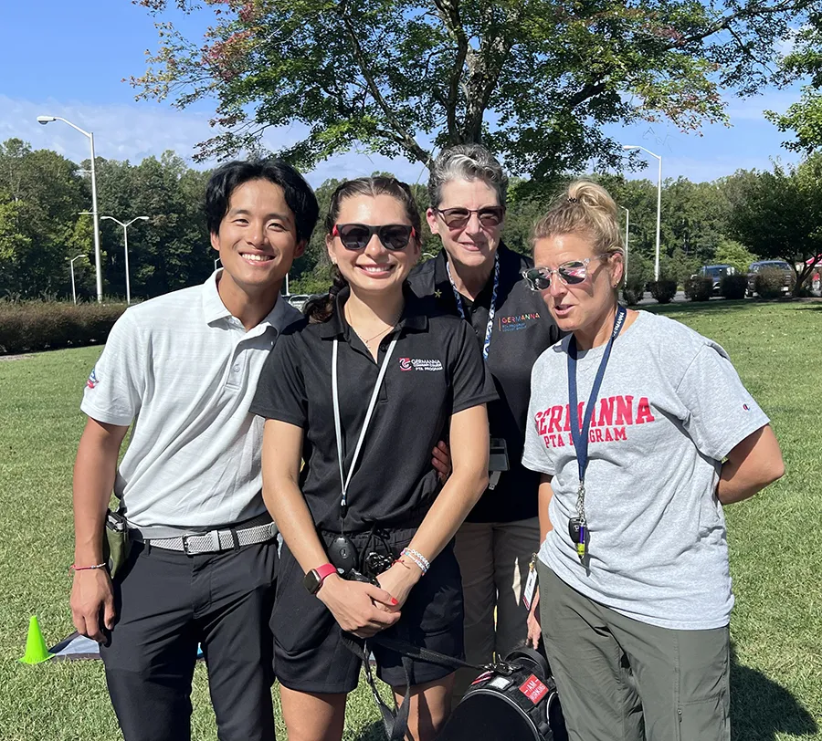Four Germanna staff members gather on campus on a sunny day to welcome visitors to the Connected Community Fall Festival
