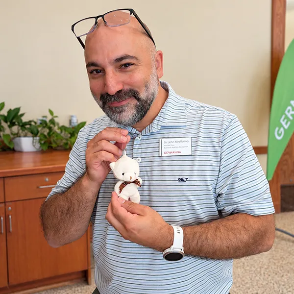 Associate Dean of Business and Workforce Development John Stroffolino poses with a tiny teddy bear during National Bring Your Teddy Bear to School Day.