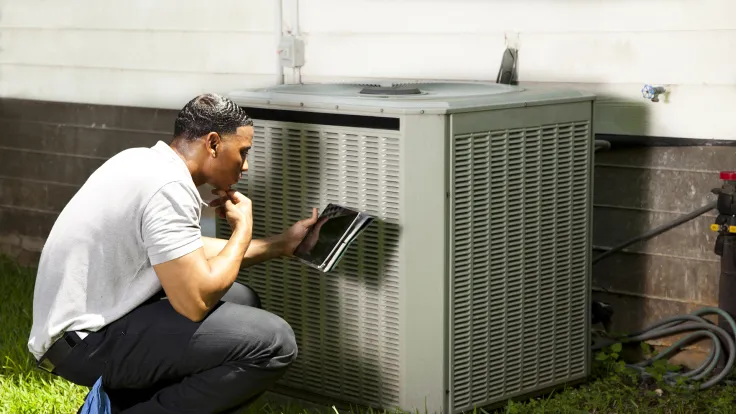 HVAC technician diagnosing heat pump