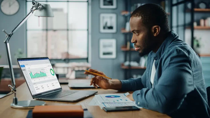 African American specialist working on laptop computer