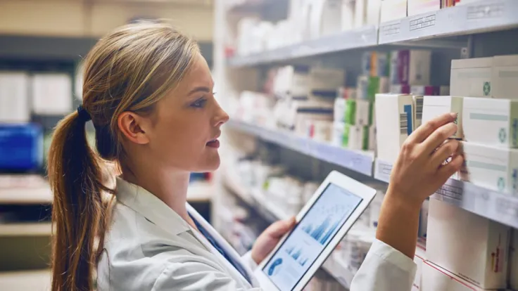 A Pharmacy Technician Monitoring the Pharmaceutical Inventory Using a Tablet
