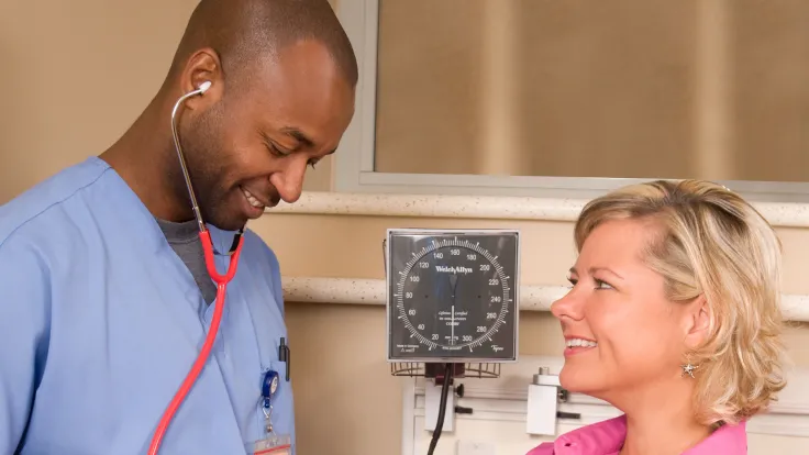 male nurse taking female patient blood pressure