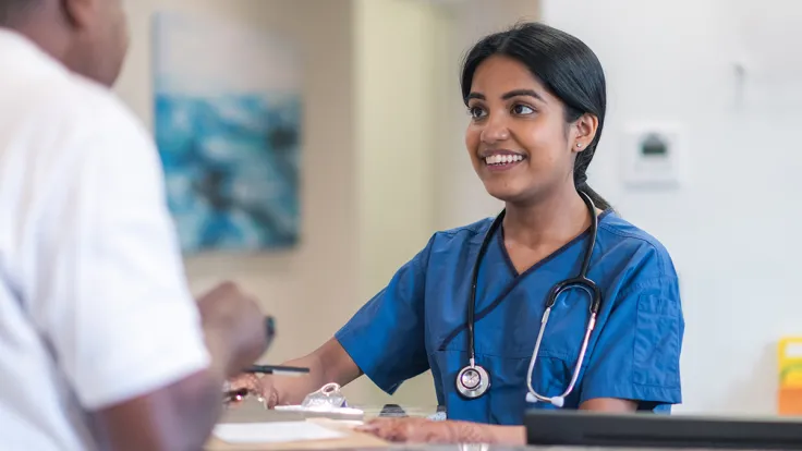 Female clinical medical assistant talking to male coworker