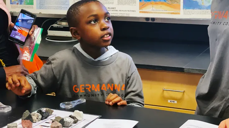A child listening to a teacher talking about rocks and minerals