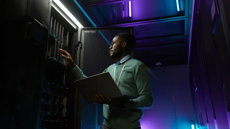 A man makes adjustments to a server rack