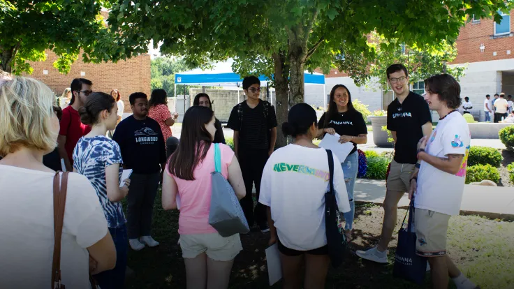 Students on a tour listening to a tour guide speaking