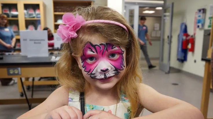 A young child wearing playful face paint