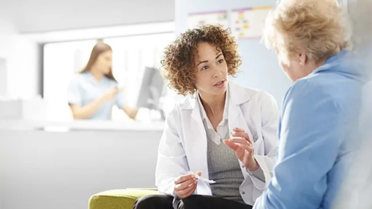 A behavioral health technician talks to a patient