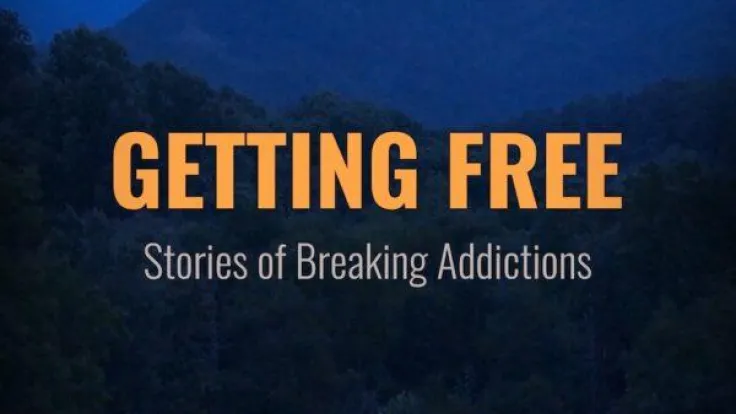 The movie poster for the documentary "Getting Free: Stories of Breaking Addictions". A small house in the middle of a forest is lit from the inside on a dark night, with mountains in the background.